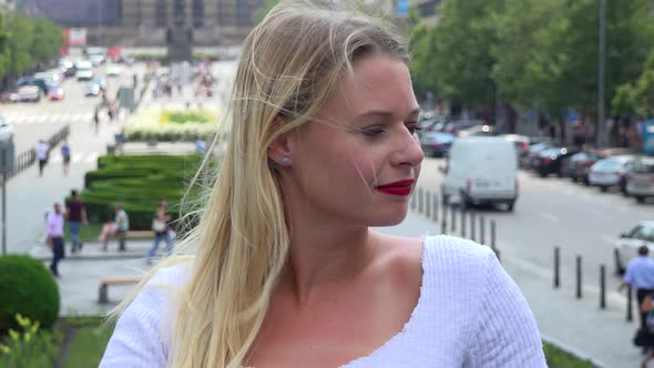 A Young Beautiful Woman Looks Around for Someone in an Urban Area - Closeup