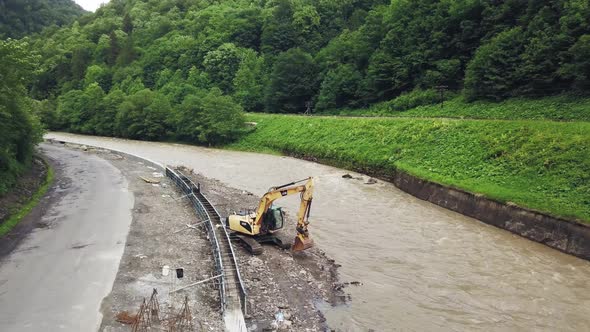 Yellow dredge Excavator working in the mountain river, scooping excavator bucket. Extracting gravel