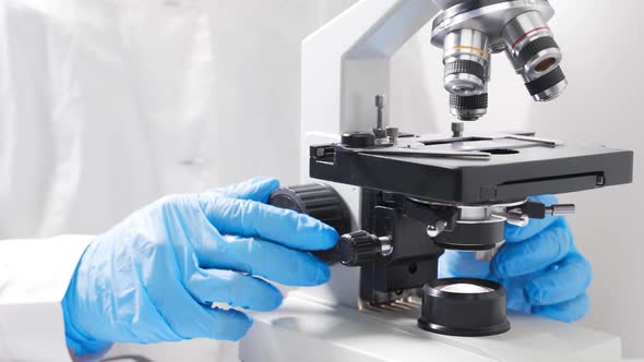 A Scientist Analyzes a Blood Sample with a Microscope