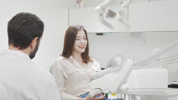 Happy Woman Looking in the Mirror After Dental Checkup