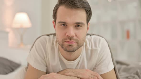 Close Up Young Man Looking at Camera in Bed