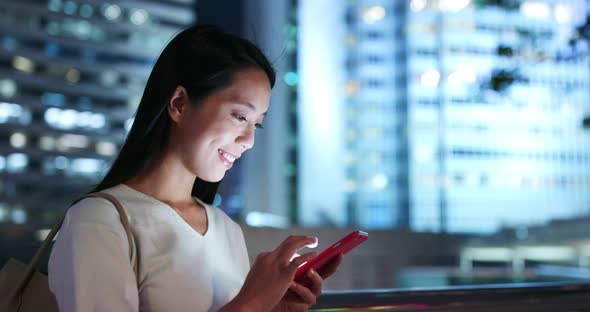 Woman use of mobile phone in city at night