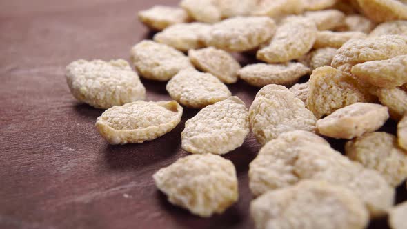 Quinoa cereal gluten free flakes on a wooden board. Crunchy vegetable grain breakfast