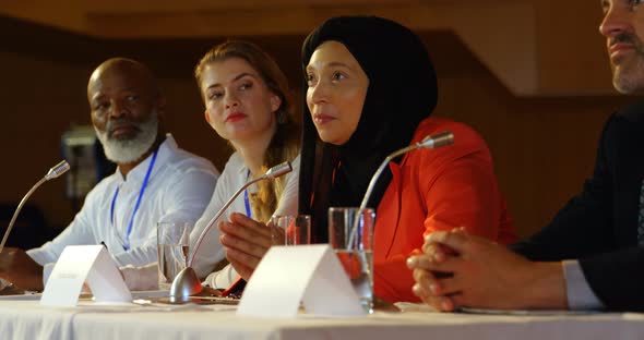 Businesswoman speaking in speaker at table in auditorium 4k