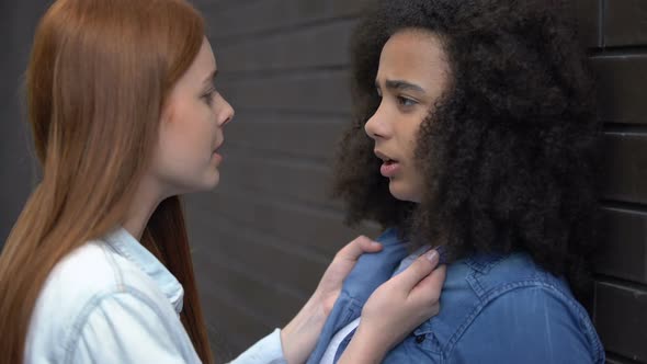 Angry Female Teenager Pushing Scared Classmate Against Wall in Campus Backyard