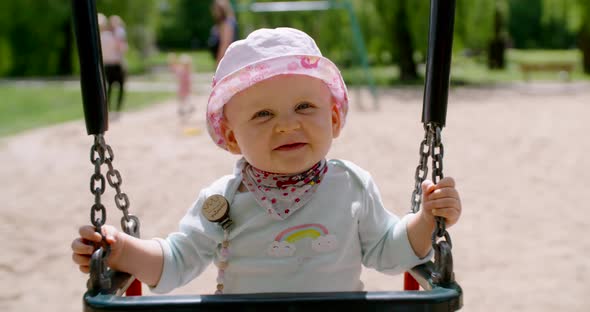 Baby girl playing on swing