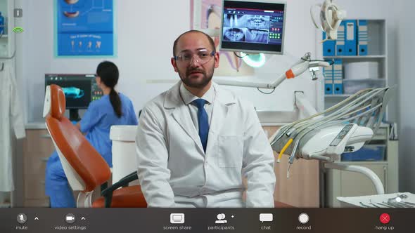 Dentist Looking at Camera Talking Online with Patients