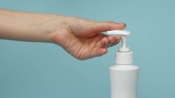 Closeup Woman Hand Pressing a Bottle with a Liquid Soap and Washing Her Hands To Protect Against