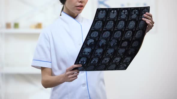 Experienced Neurosurgeon Looking at Brain X-Ray, Upset With Examination Result