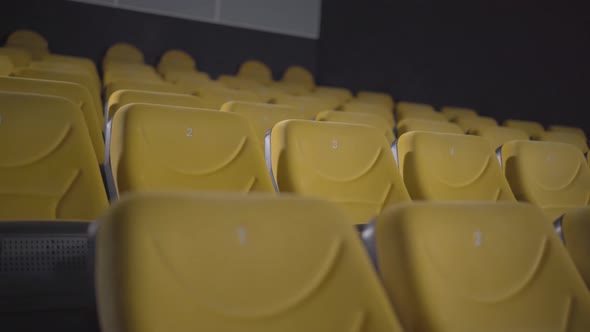 Camera Moves Up Along Rows of Yellow Chairs in Movie Theatre. Empty Cinema Hall During Covid-19