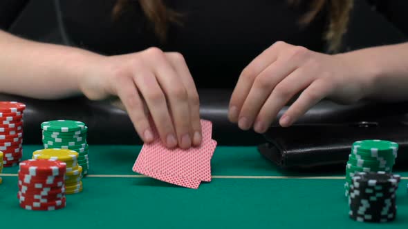 Woman Taking Pile of Dollars From Purse and Betting All-In Looking at Her Cards