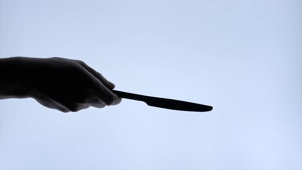 Hand Man Throw a Knife Black Silhouette on White Isolated Background