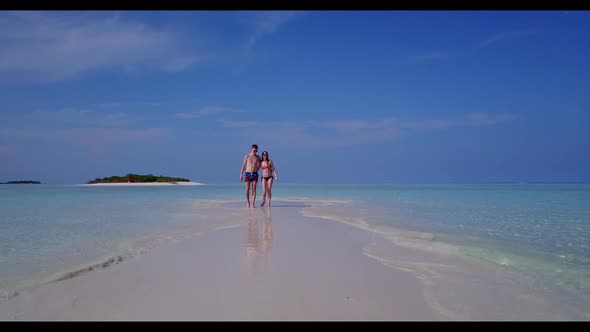 Romantic couple tanning on tropical seashore beach adventure by aqua blue sea with white sandy backg