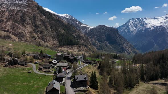 Picturesque Italian alp village in scenic valley surrounded by pointed mountains