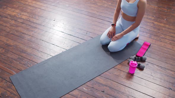 Young and sporty girl in sportswear is doing exercises at home.