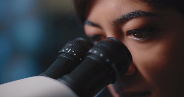 Close Up of a Female Research Scientist Eyes,looking at Samples Under Microscope