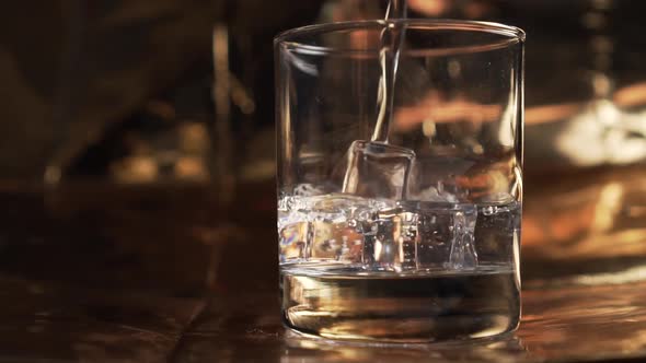 Pure mineral water is poured into a glass with ice cubes 