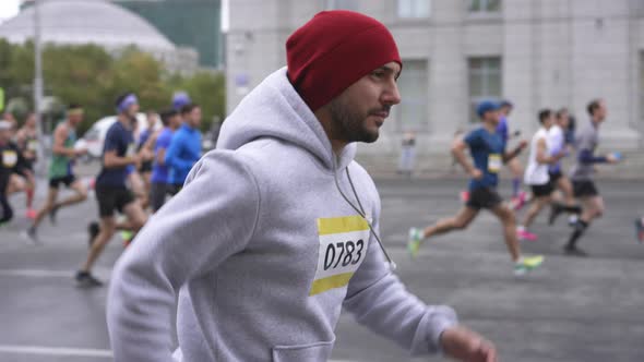 Marathon Athlete Running in Group of Other Sportsmen During Athletic Competition