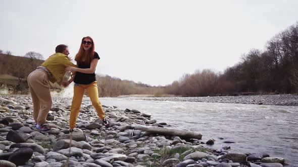 Two Happy Girls are Having Fun on the River Bank