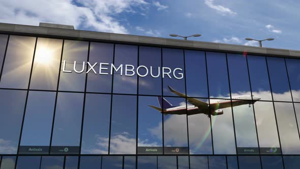 Airplane landing at Luxembourg airport mirrored in terminal alt