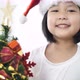 Happy lovely Asian girl putting ornament on Christmas tree and showing all together. - VideoHive Item for Sale