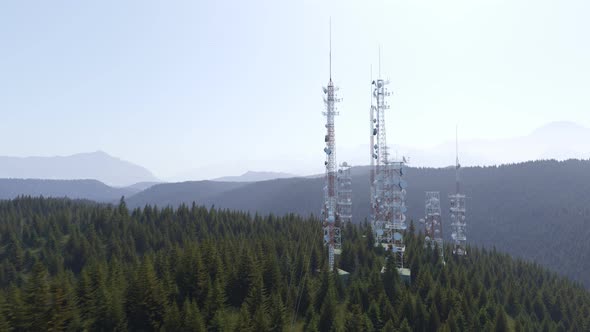 Antennas complex on a forested hill. Radio masts and towers for broadcasting.