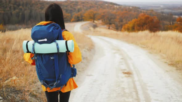 Woman Traveler with Backpack Hiking in Mountains