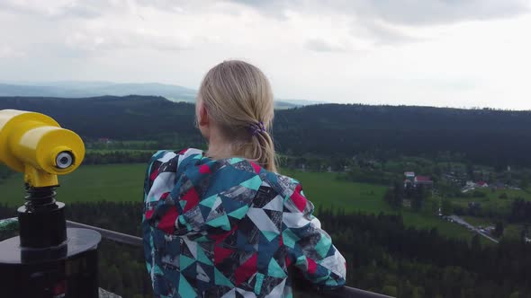 Woman Looks at a Beautiful View on Top of a Mountain