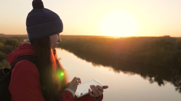 Carefree Cheerful Girl Travels with a Digital Tablet in Nature