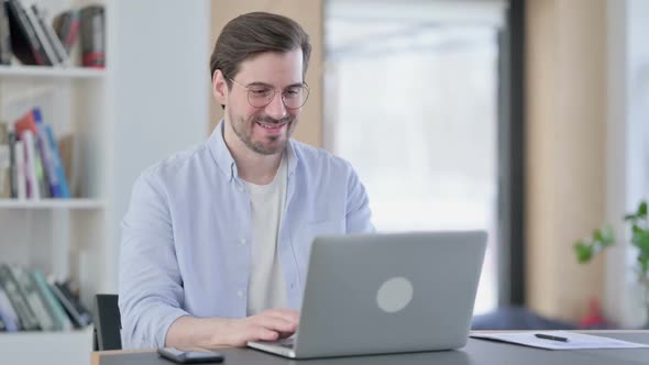 Man in Glasses Talking on Video Call on Laptop