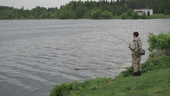 Fisherman Spinning Fishing Reel. Fishing on Summer River