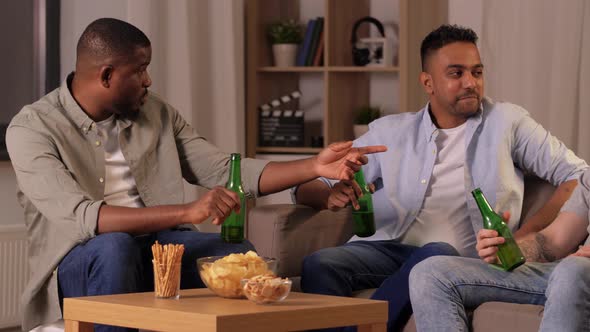 Male Friends Drinking Beer with Crisps at Home