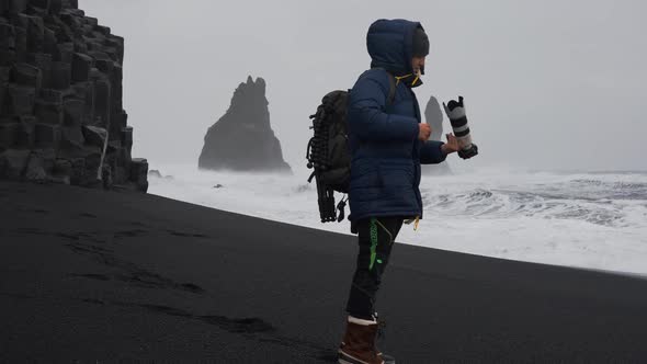 Photographer With Camera On Black Sand Beach