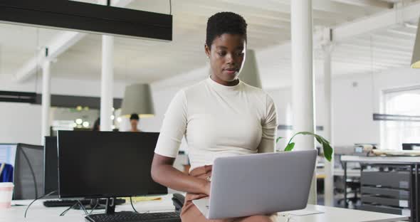 Focused african american businesswoman working on laptop in office