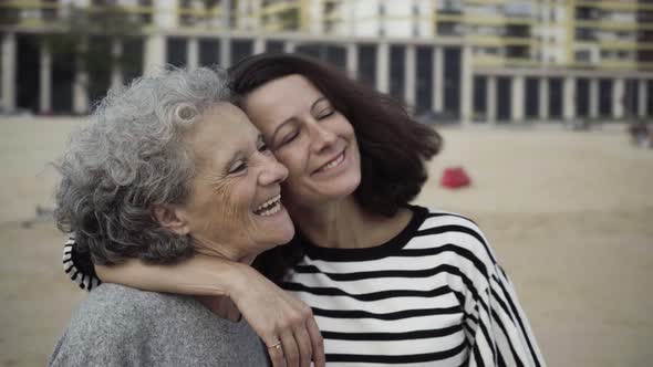 Happy Adult Daughter and Senior Mother Hugging, Talking, Kissing