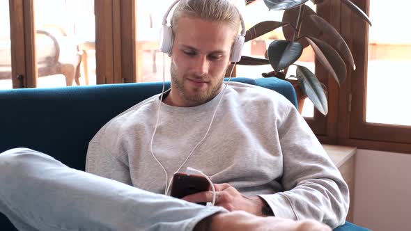 Man listening to music with mobile phone at home