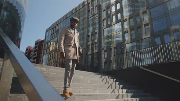 Young Afro-American Businessman Walking Downstairs in City