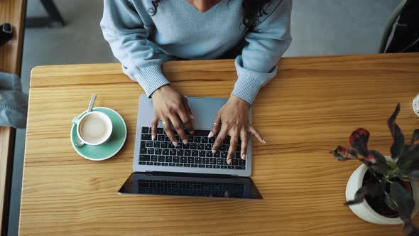 Female African hands typing on laptop