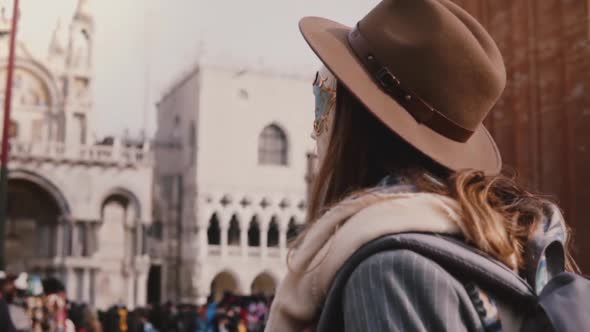 Close-up Back View Shot of Woman with Long Hair Wearing Stylish Hat and Carnival Mask in San Marco