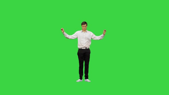 Young Man in White Shirt Dancing a Modern Dance with Bent Arms on a Green Screen, Chroma Key