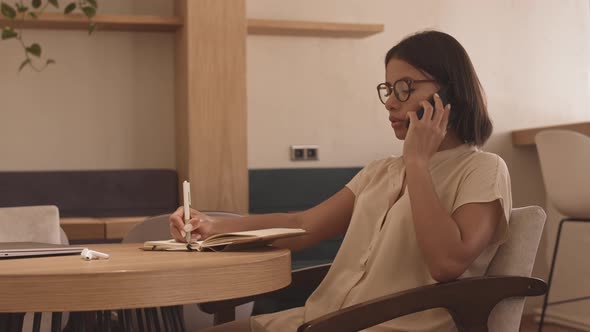 Woman Having Business Call in Cafe