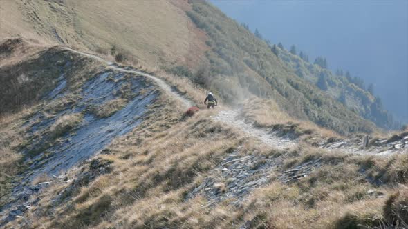 Mountain biker biking downhill on a rocky trail in the mountains