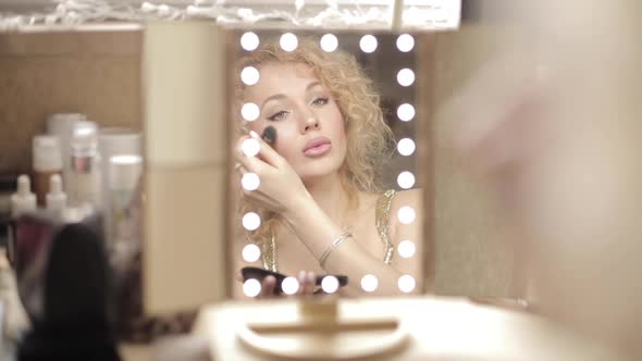 Blonde Looking at Mirror and Doing Makeup at Home