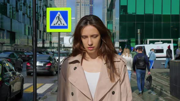 Brownhaired Woman Walks at Street in City