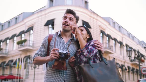 Young Mixed Race Tourist Couple Taking Pictures on Vintage Camera While Walking Through the City