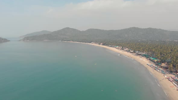 Turquoise ocean shore in Palolem Beach in southern Goa, India - Aerial Wide shot
