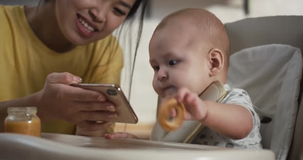 Mother Showing Smartphone To Baby