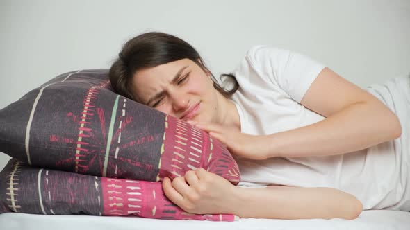 A Woman Tries to Fall Asleep Rubs a Sore Neck and Lies Down on a Comfortable Orthopedic Pillow