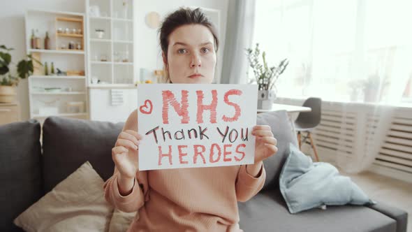 Young Woman Posing with «NHS thank you heroes» Inscription on Paper