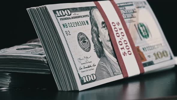 Bundles of Dollars Rotate on Black Background